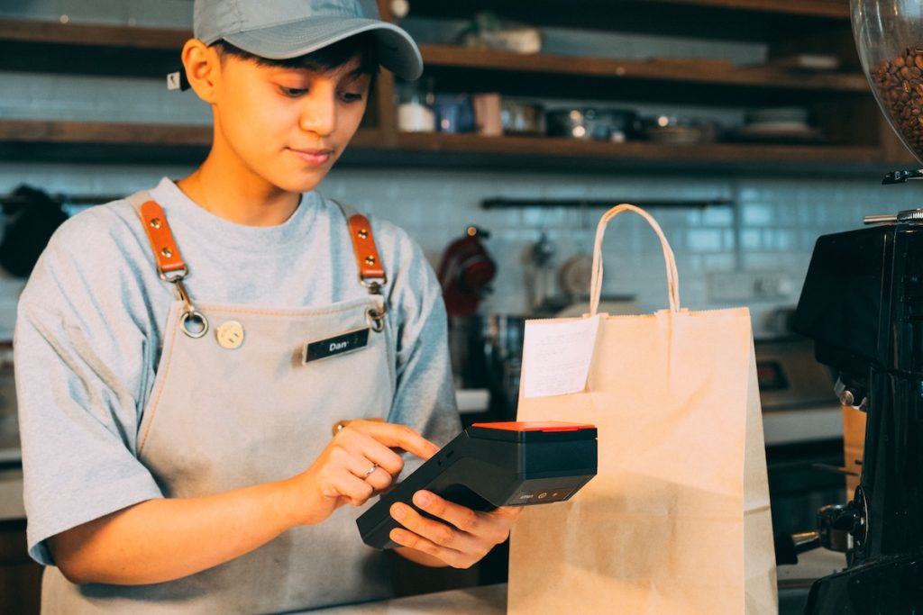 Commerçante qui prépare une commande click and collect au comptoir de son magasin
